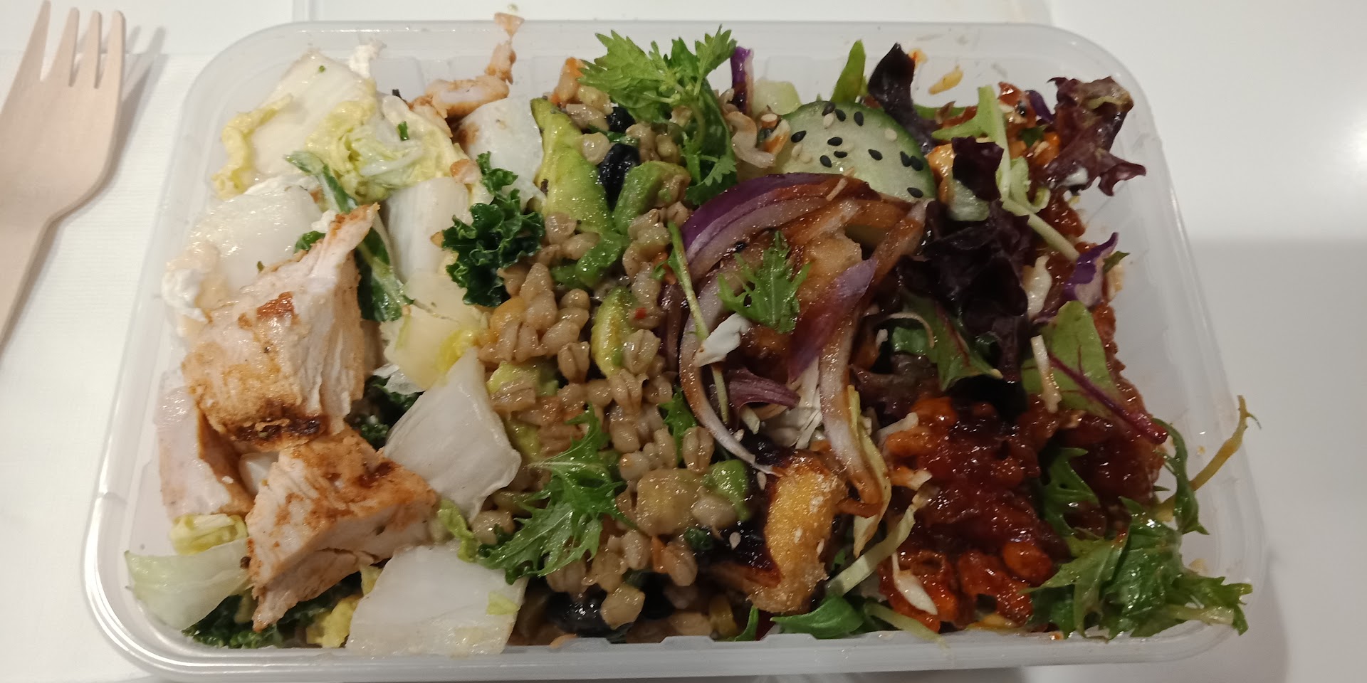 Fresh Rollin's salad bowl with chicken, grains, greens, cucumber, and onion