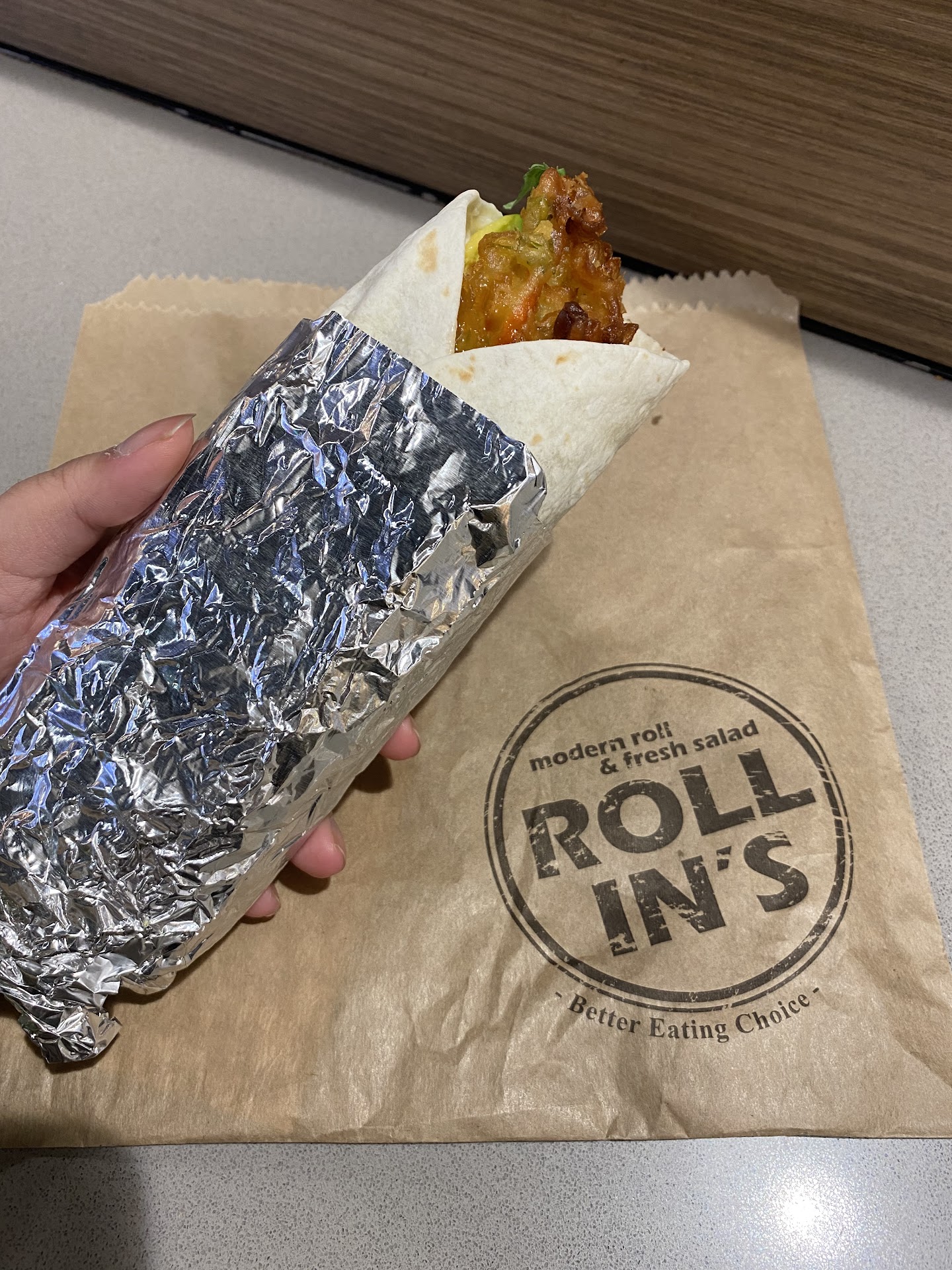 Wrapped Rollin's roll on branded brown paper packaging